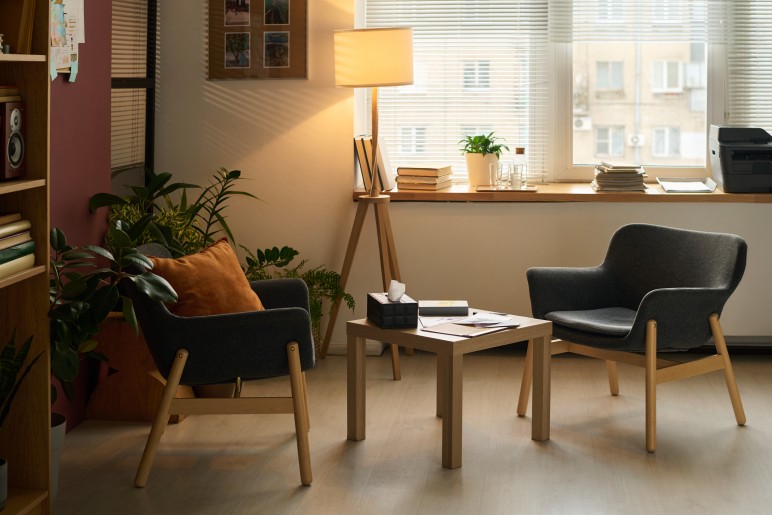 Welcoming psychologist office with two chairs, table and lamp